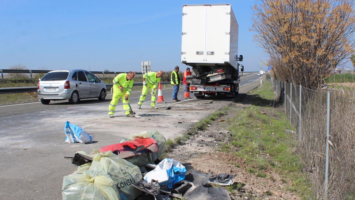 Operarios del servicio de Carreteras trabajan en el lugar del accidente.