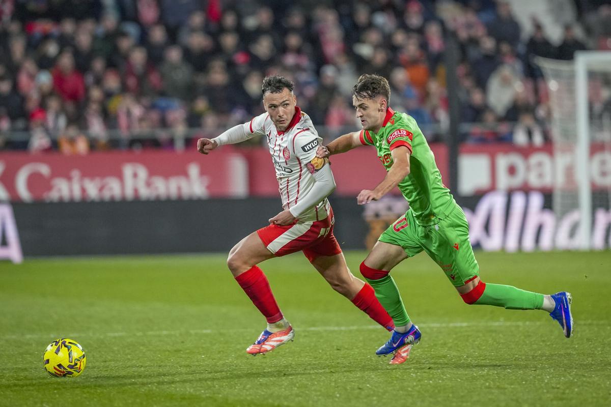 El defensa del Girona, Arnau Martínez (i), disputa el balón ante el centrocampista de Osasuna, Aimar Oroz, durante el encuentro correspondiente a la jornada 19 de Laliga EA Sports.