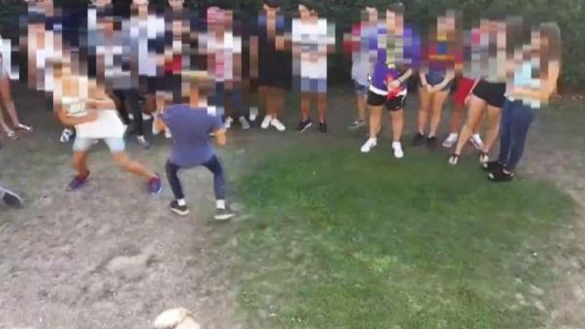 Captura de un vídeo de jóvenes pegándose con  gente de público.