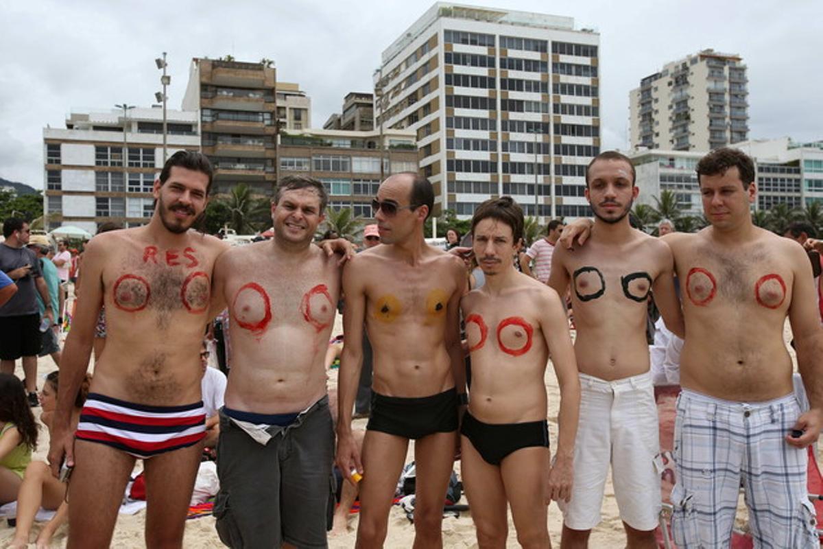 Uns homes participen en una protesta a la platja d’Ipanema on desenes de persones es van congregar per exigir la legalització del topless, que està prohibit en aquesta ciutat brasilera per lleis dictades en defensa de la moral.