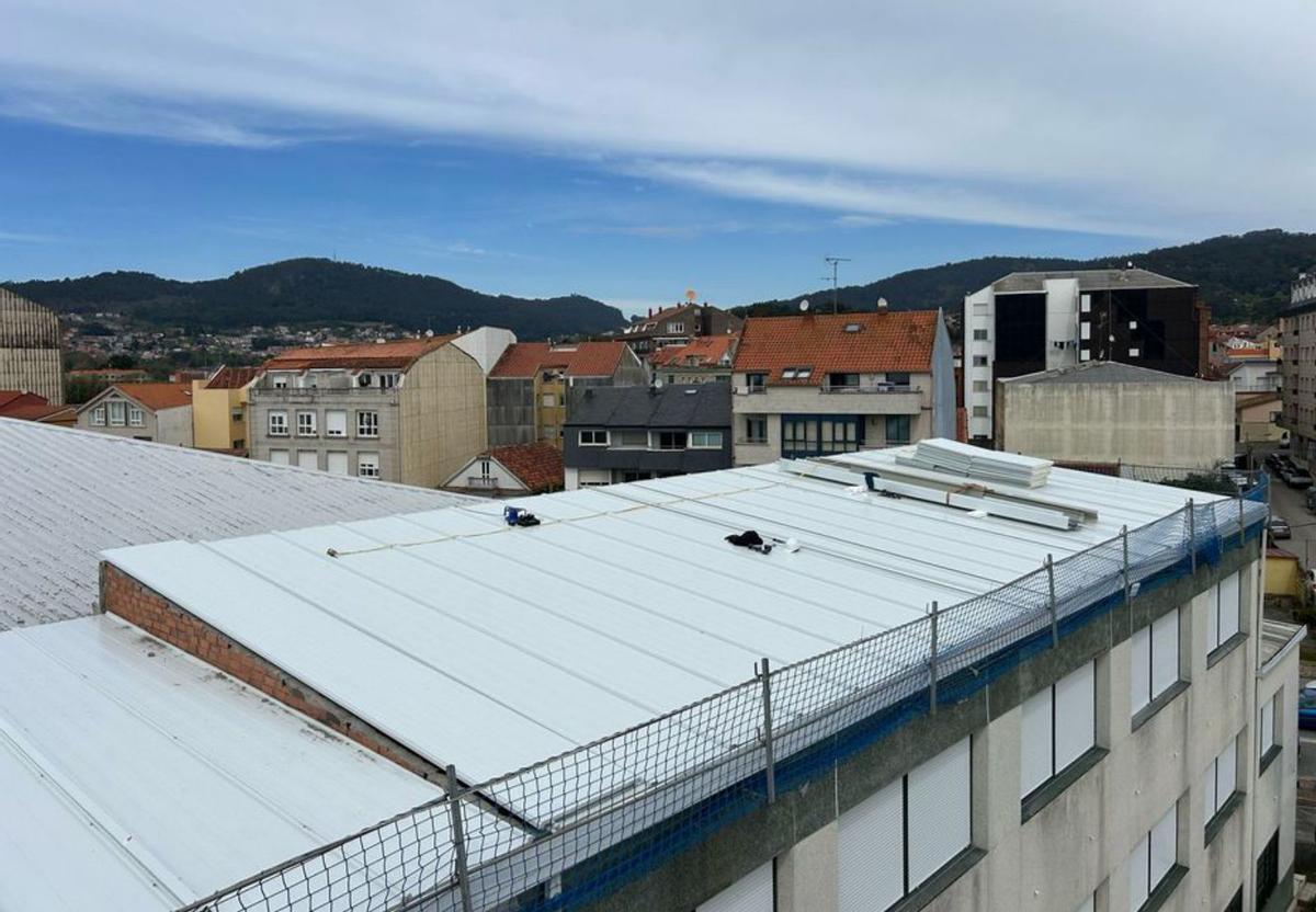 Operarios trabajando en la cubierta del IES María Soliño, ayer a mediodía. | G.Núñez
