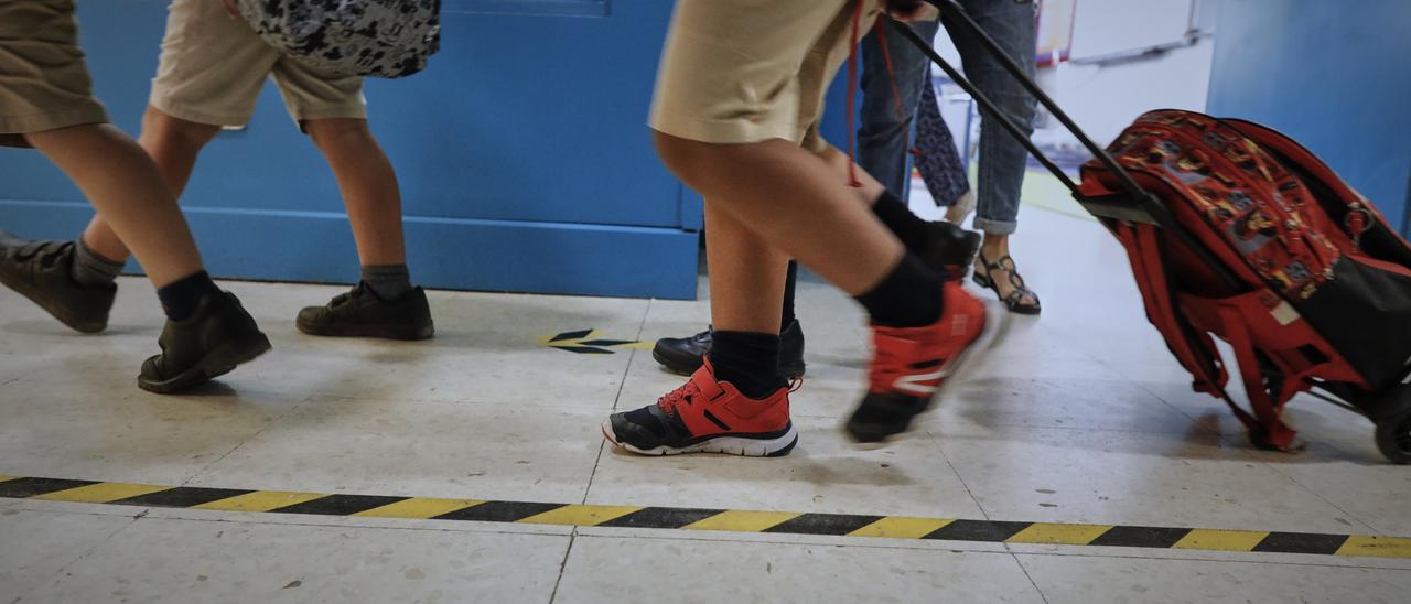 Niños en el pasillo de un colegio.