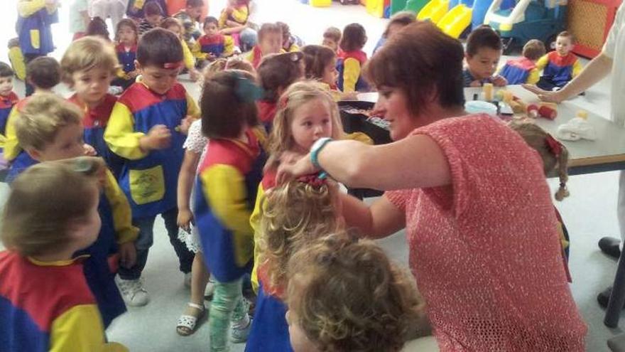 Una peluquera hace una demostración de su profesión a los niños de la guardería.