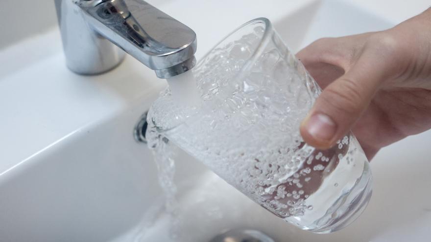 Imagen de archivo de una persona llegando un vaso de agua de un grifo.