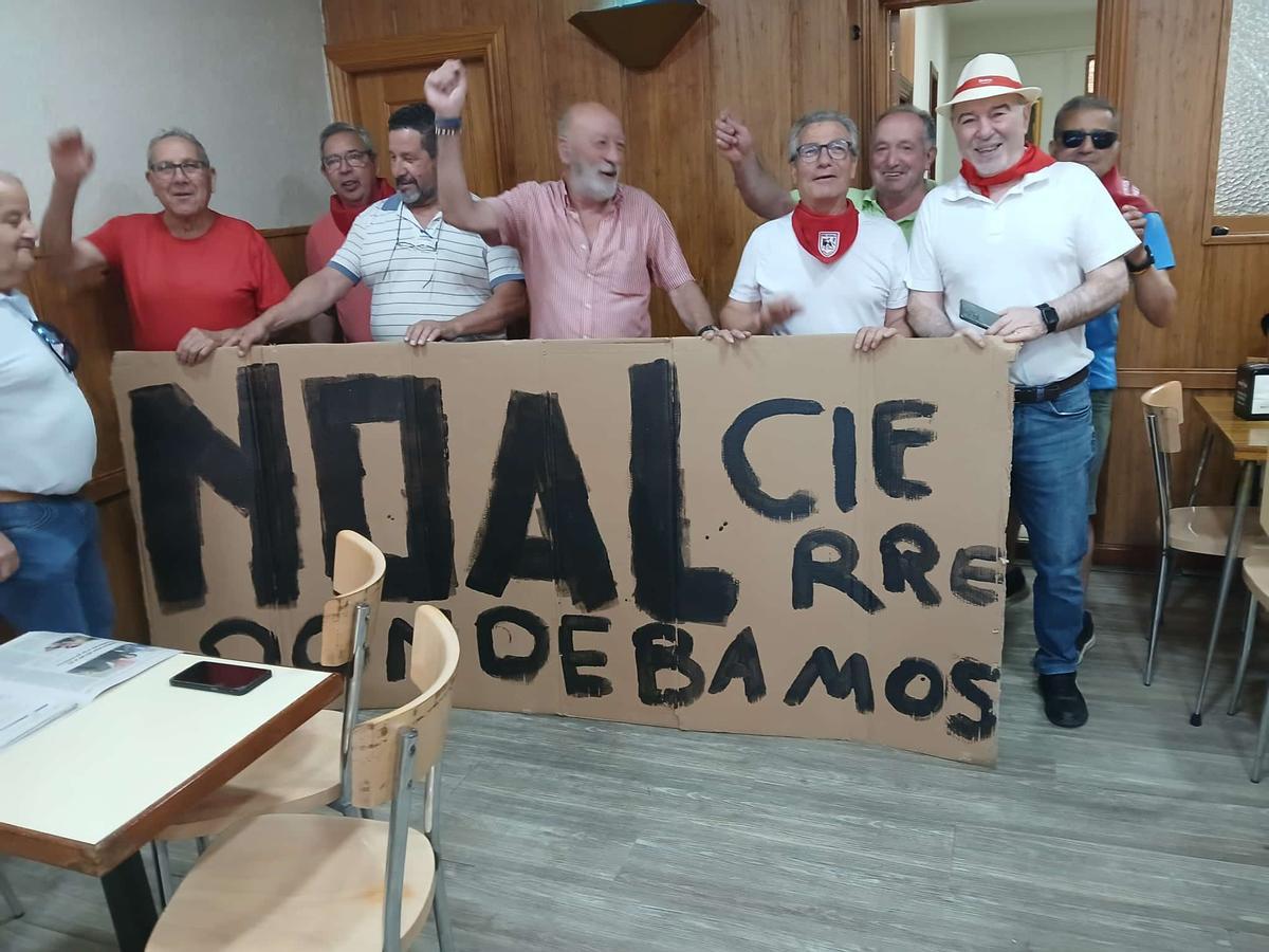 Otro grupo de parroquianos con la pancarta contraria al cierre dentro del local.