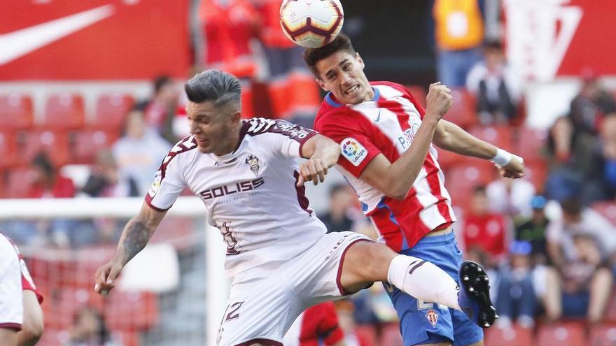 Dani Torres disputa un balón con Pablo Pérez en El Molinón