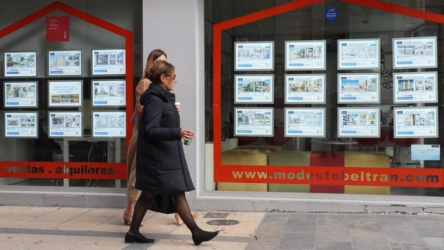 Dos mujeres pasan por delante del escaparate de una inmobiliaria de la capital de la Plana, en imagen de archivo.