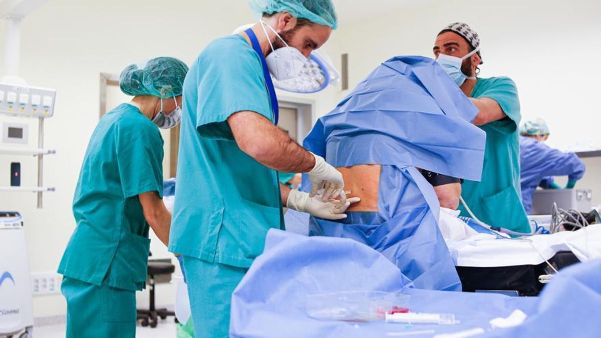 Un profesional administra anestesia raquídea a un paciente en quirófano.