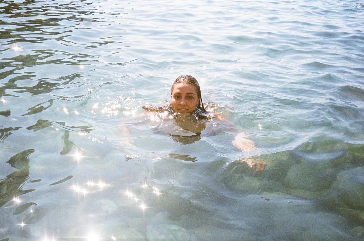 Mujer dando un baño y disfrutando del mar.