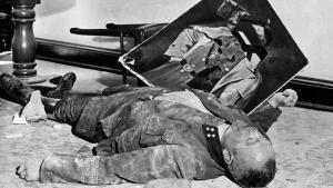 El comandante nazi del batallón de la Volkssturm, Walter Dönicke, tras envenenarse, junto a un retrato desgarrado de Adolf Hitler.