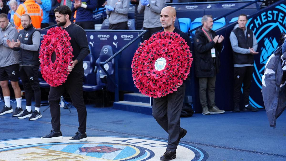 Russell Martin y Pep Guardiola entran al césped del Etihad con sendas coronas de amapolas rosas.