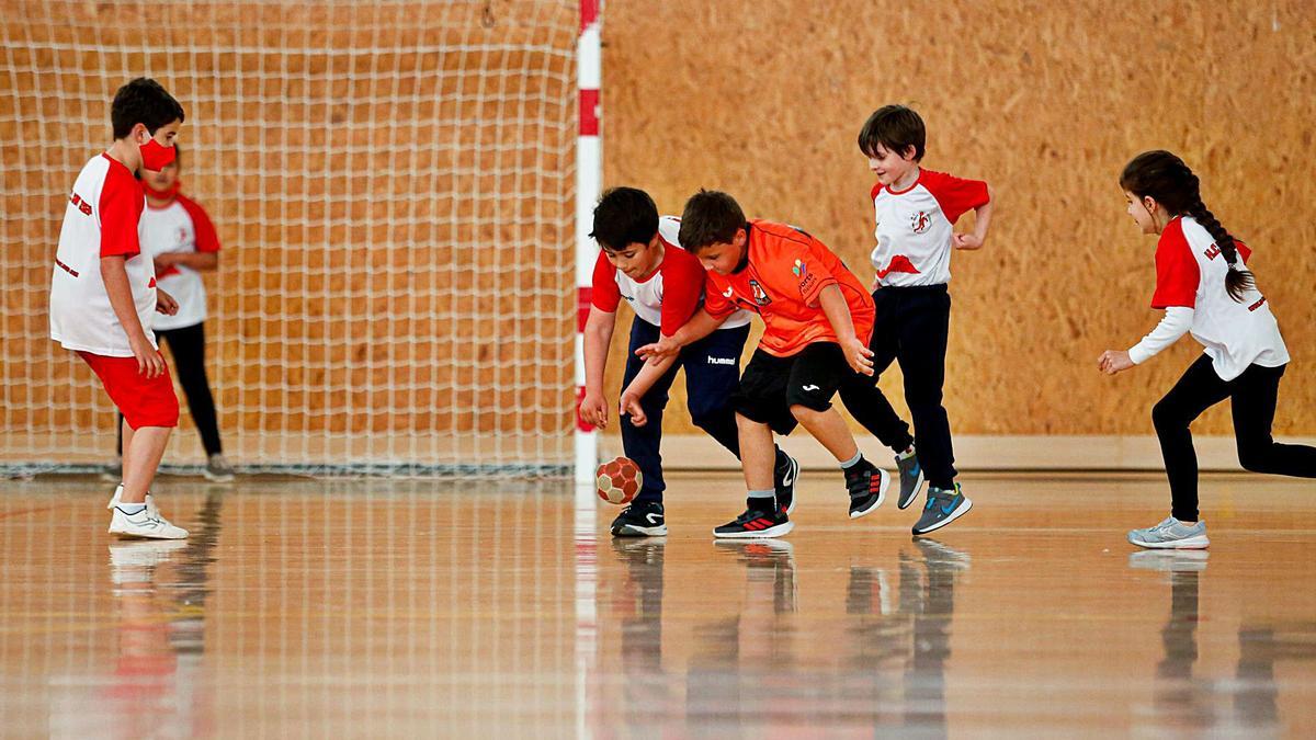 Varios niños se emplean a la hora de hacerse con la pelota y entran en contacto para tratar de adelantarse a su rival.