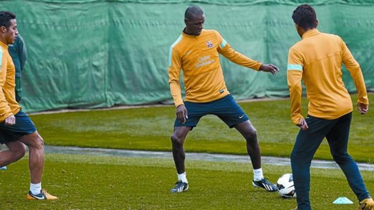 Abidal participa en un rondo junto a Thiago y Alves (de espaldas), ayer en la ciudad deportiva de Sant Joan Despí.