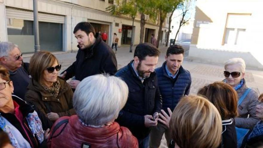 Alumnos de Aulas de la Tercera Edad charlan con los concejales del PP en la calle.