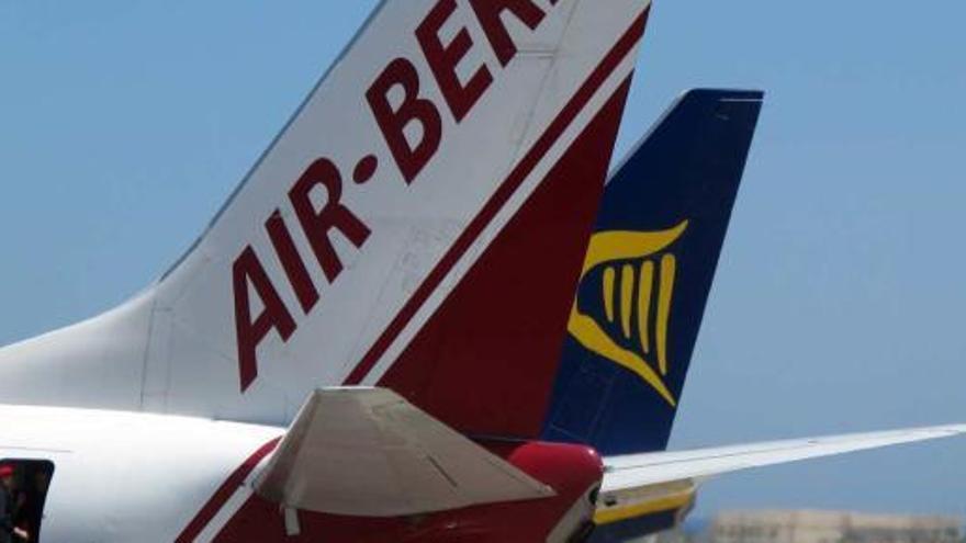 Un grupo de pasajeros embarca en un avion de Air Berlin en el aeropuerto de El Altet. Junto al aparato, otro de Ryanair.