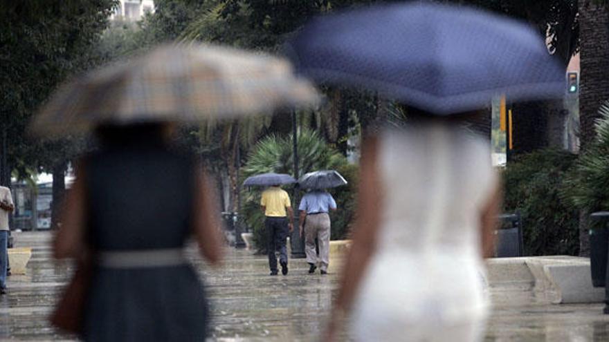 Una pareja de viandantes se protege de la lluvia en la capital.