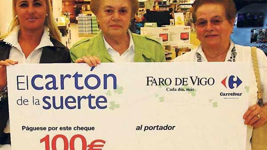 Pilar Rodríguez, Carmen Blanco y Concepción Fernández, con uno de los cheques de compra.