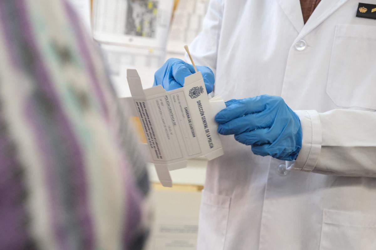 Un agente de la Policía Nacional guarda una muestra de ADN, tomada con un hisopo, para poder analizarla.