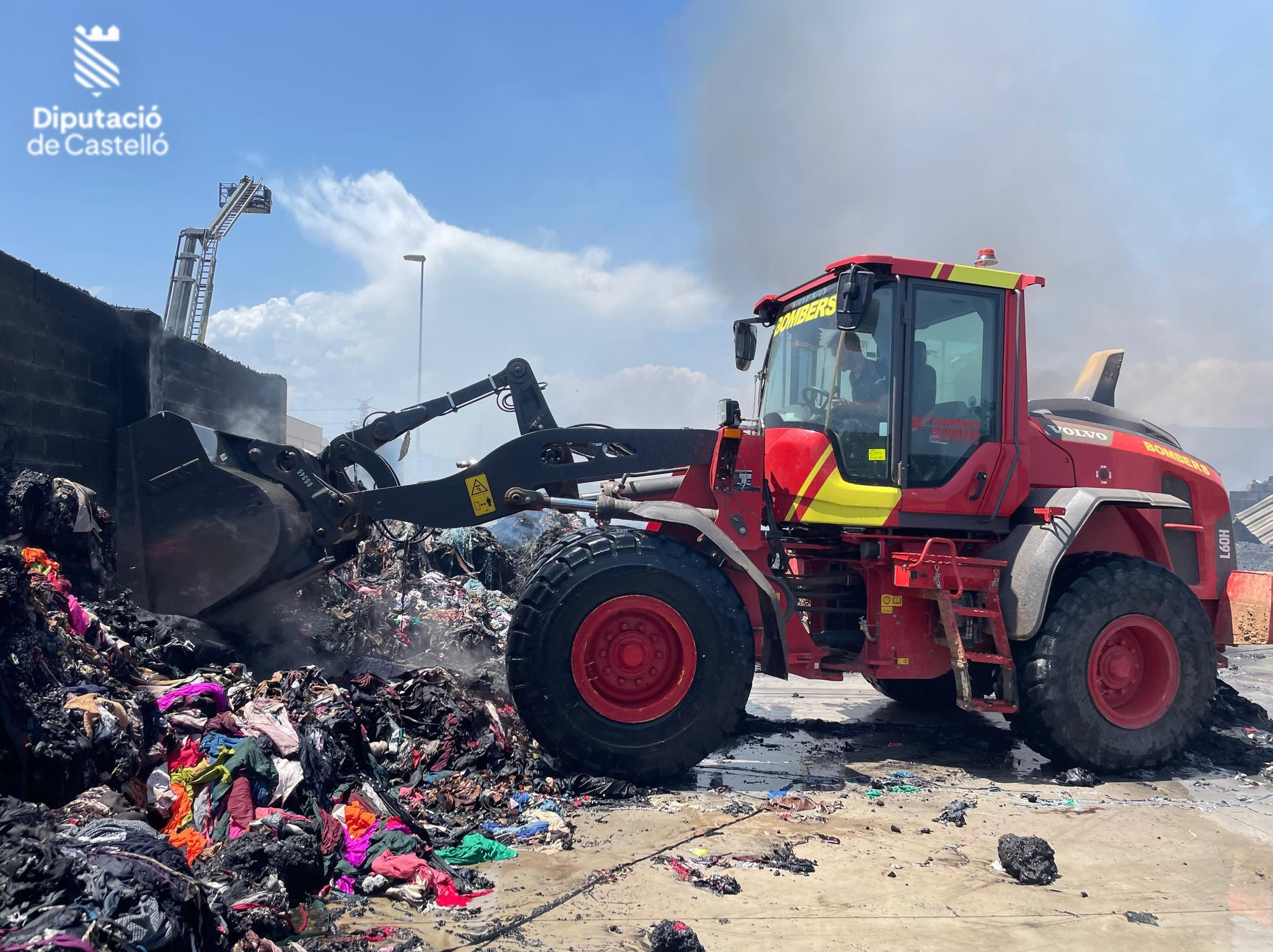 Los bomberos siguen trabajando en el en el incendio industrial de la nave de textil de Almassora