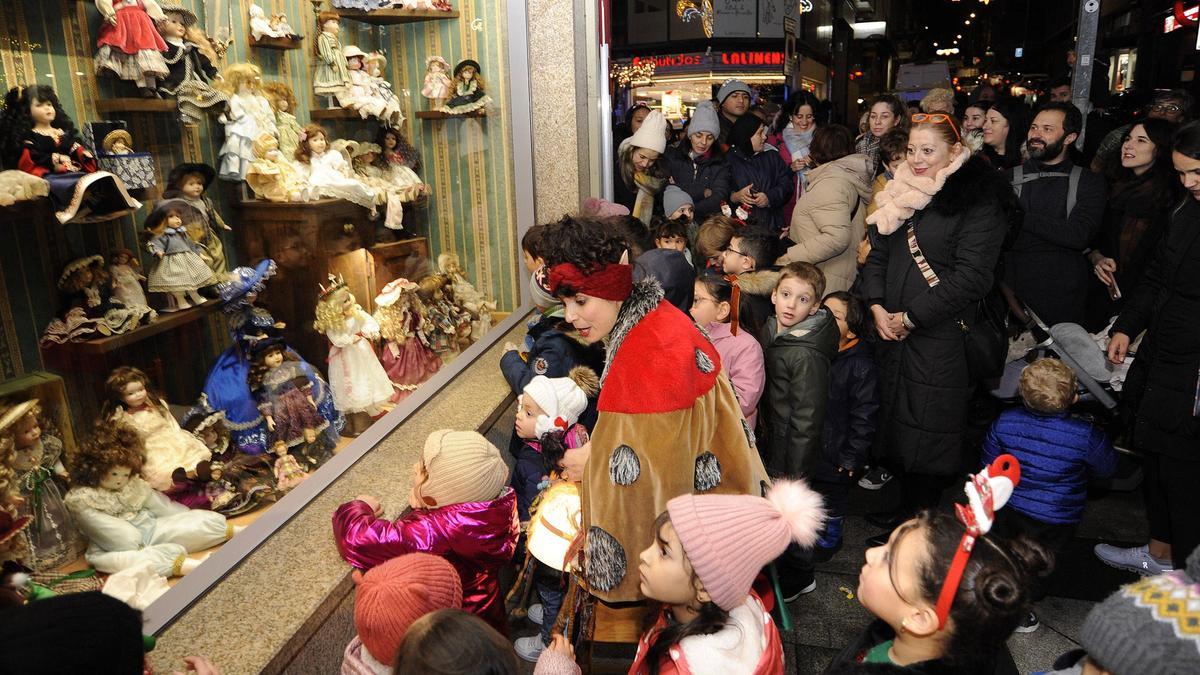 Los niños admiran el Escaparate Máxico de las muñecas antiguas.