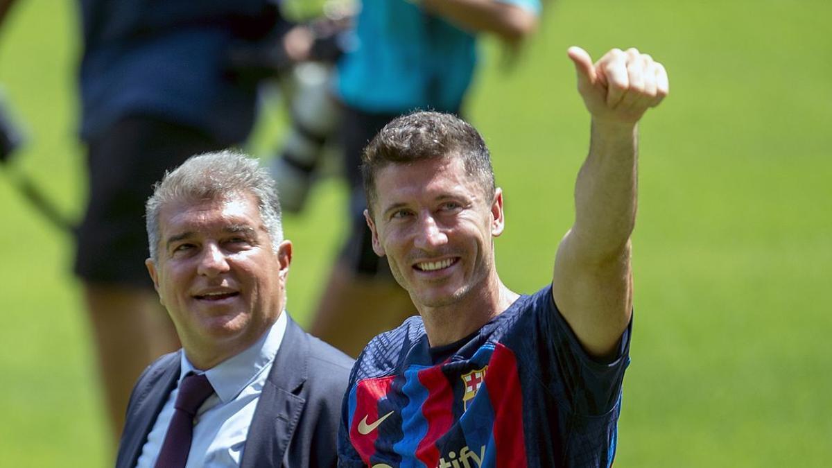 Robert Lewandowski sobre el césped del Camp Nou junto al presidente Joan Laporta.