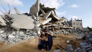 Niños palestinos junto a las ruinas de un edificio en Rafah, tras un ataque israelí.