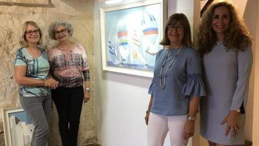 Las hijas de Ferrer Guasch y la galerista Marta Torres rodeadas de los cuadros de la muestra.