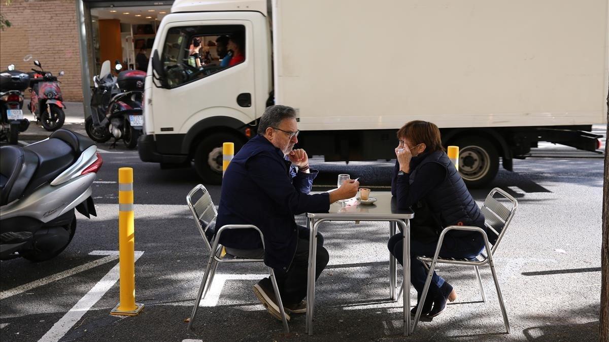  En las nuevas terrazas de todo tipo de bares y  restaurantes, a partir de zonas ganadas al coche,  se crean situaciones curiosas, compartiendo espacio con motos y cohes como en la imagen desayunando en la  Fleca Escorial de la calle Escorial del barrio de Gracia 