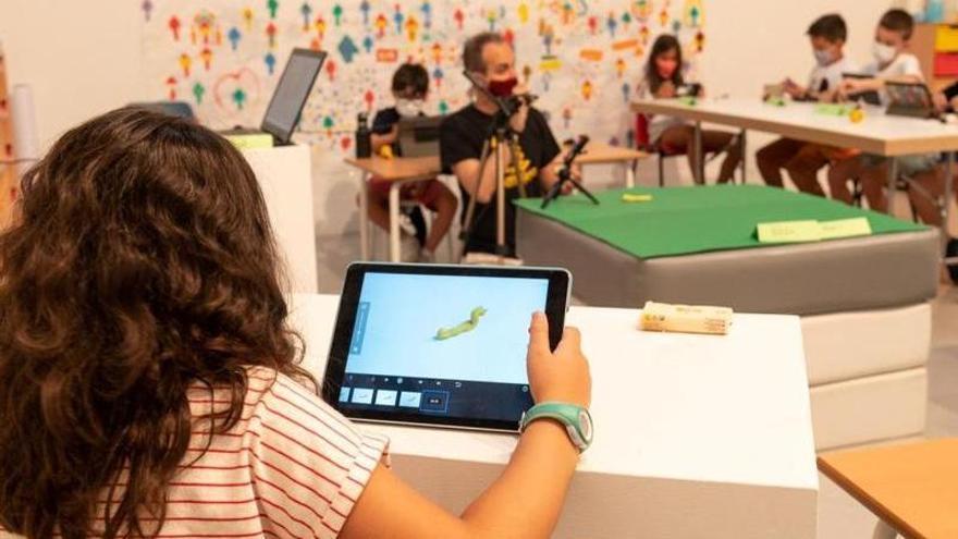Una niña trabaja con una tablet en el taller.