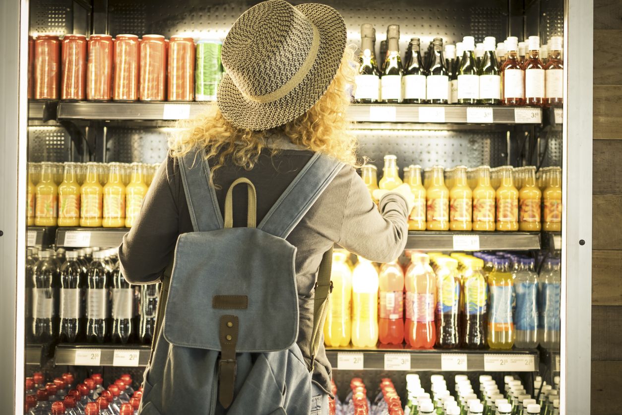 Imagen de una mujer viendo qué beber en el aeropuerto.