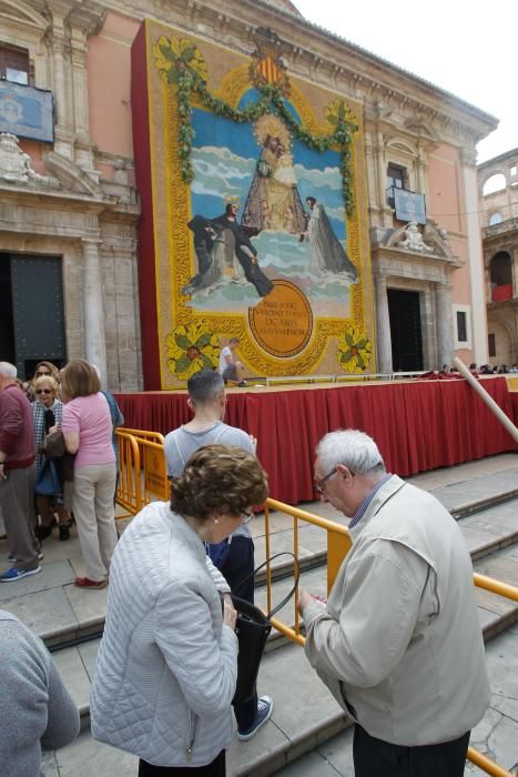 Numerosas personas acuden a la plaza de la Virgen de València para contemplar el tapiz floral