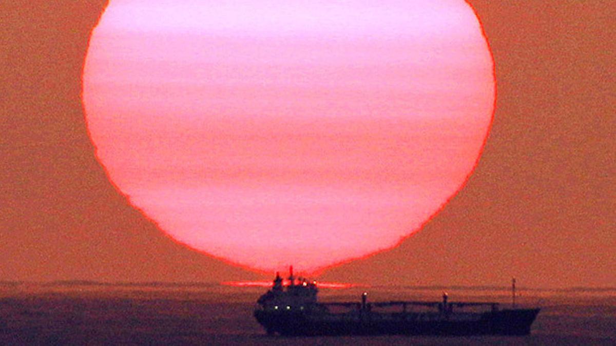 El sol s’alça sobre l’oceà Índic il·luminant un vaixell en la seva ruta cap a Sud-àfrica.