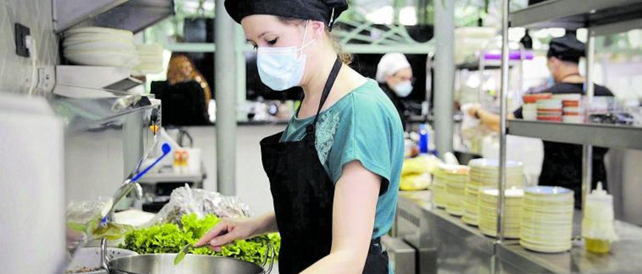 Una trabajadora en la cocina de un restaurante.