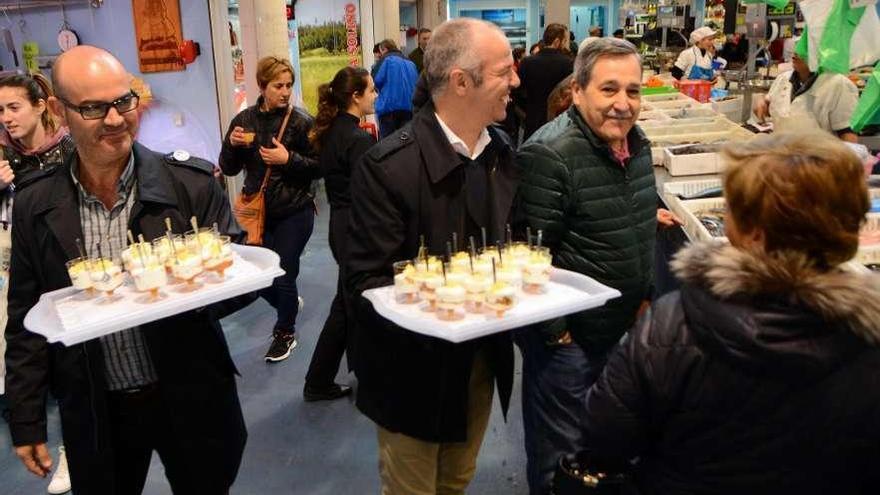 Félix Juncal y Francisco Javier Pomares ayer ofreciendo los &quot;petiscos&quot; a los clientes de la plaza. // G.N.