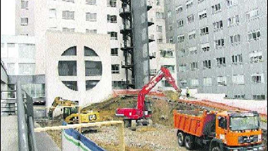 Varias excavadoras y camiones de obra, en el solar donde se levantará el nuevo edificio.