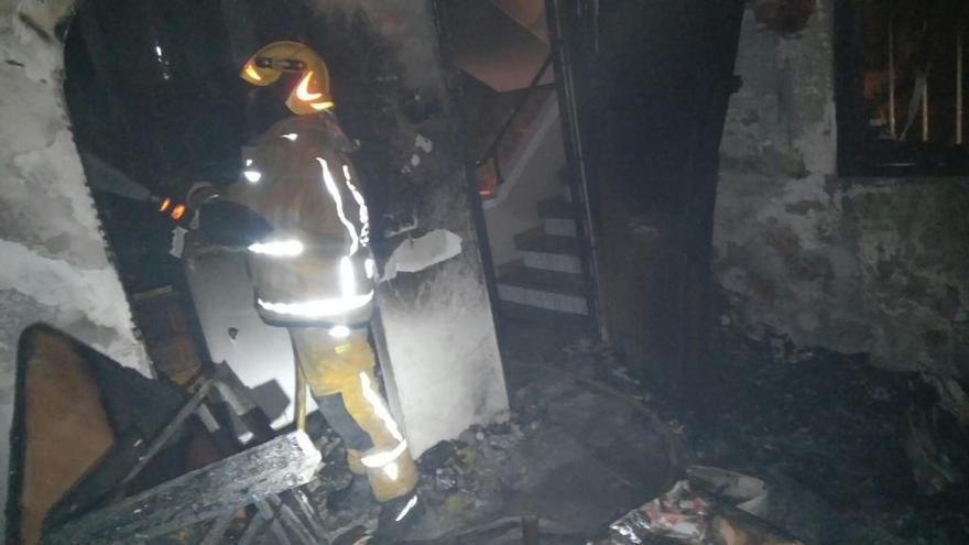 Uno de los bomberos en la casa incendiada.