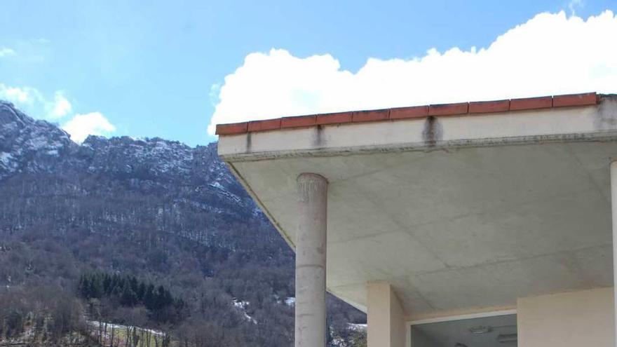 La entrada a las piscinas municipales, en primer término, con el albergue al fondo, en Campo de Caso.