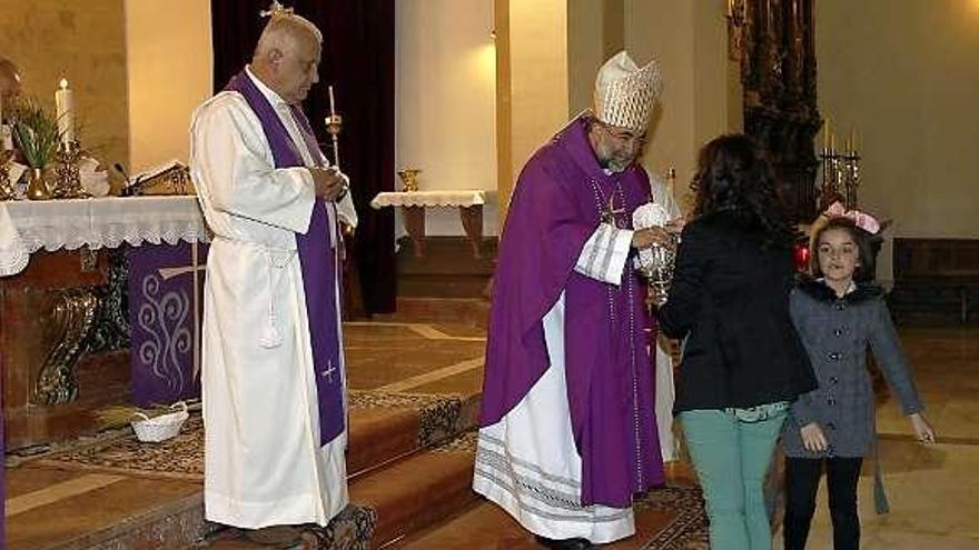 Sanz Montes con dos niñas, ayer, durante la misa.