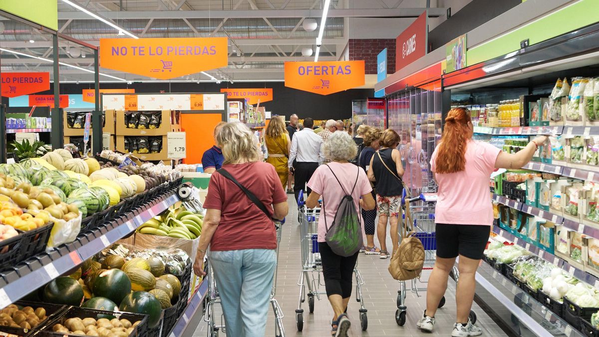 Clientes hacen la compra en la sección de frutas y verduras de un supermercado.