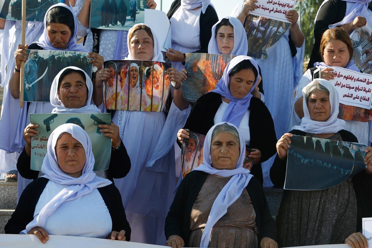 Mujeres yazidís sostienen pancartas durante una manifestación en Mosul, Irak, en junio de 2024.