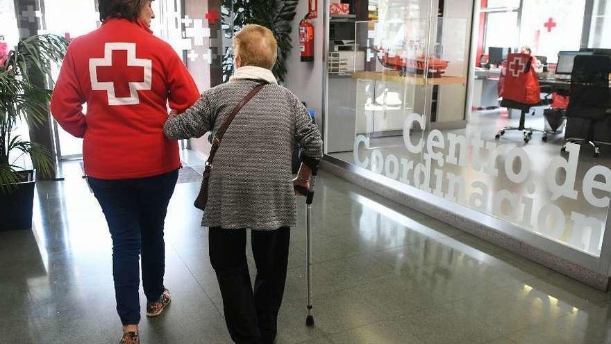 Una voluntaria de la Cruz Roja acompaña a una mujer dependiente en el centro de día de la ciudad.