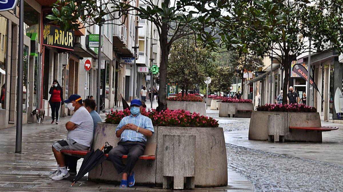 Transeúntes y vecinos en una céntrica calle de Arteixo.