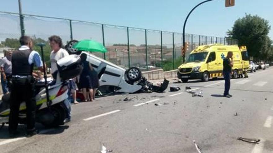 Un dels vehicles va quedar bolcat a sobre la calçada.