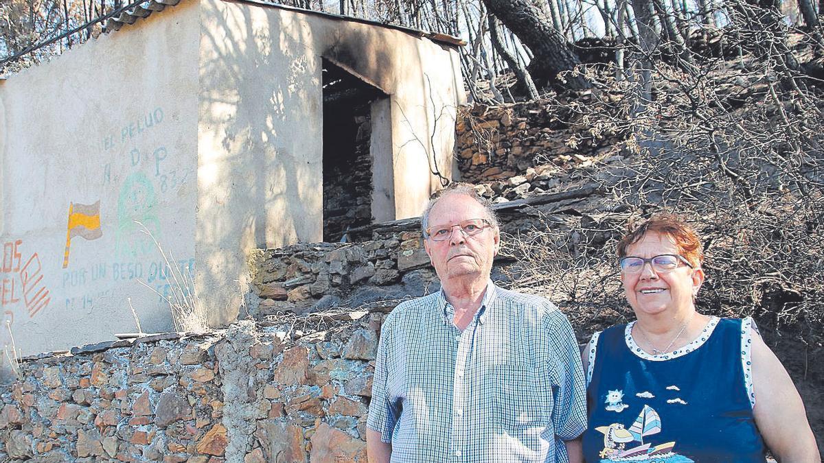 Alfonso y María, junto a los restos de la antigua carbonera de su familia, que ha sucumbido ahora a las llamas.