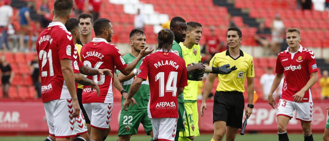 Edgar Badía, Neyder y Borja, junto a varios jugadores del Nàstic, el árbitro y su auxiliar.