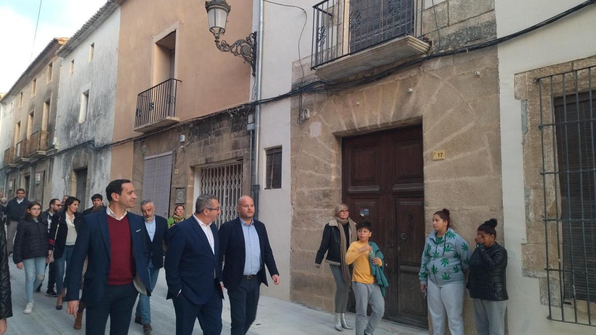 El diputado y alcalde de Benissa, Arturo Poquet, el presidente de la Diputación y el munícipe de Teulada pasan ante un arco gótico de la remozada calle Colón