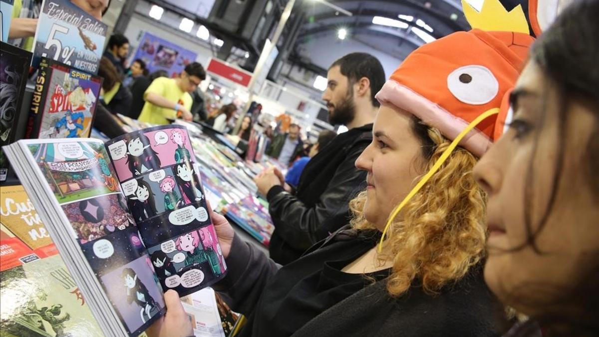 Visitantes mirando libros en un estand del Salón del Cómic, este sábado.