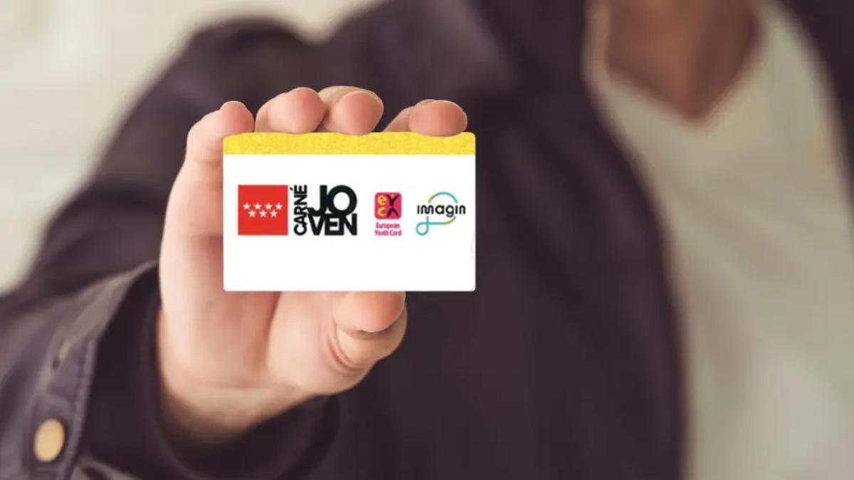 Una persona sostiene una tarjeta del Carné Joven de Madrid.