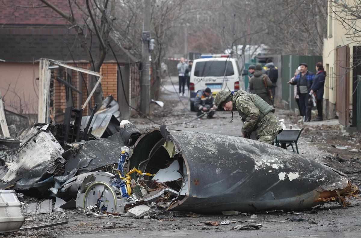 Un soldado observa los restos de un avión militar derribado en Kiev, Ucrania.