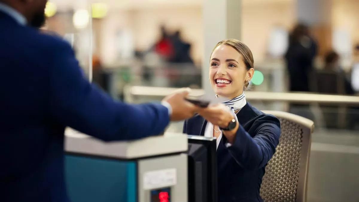 Una empleada de una aerolínea en un mostrador de facturación